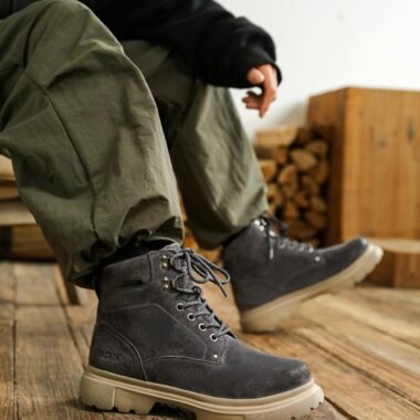 A casual shot of black boots worn on a wooden floor.