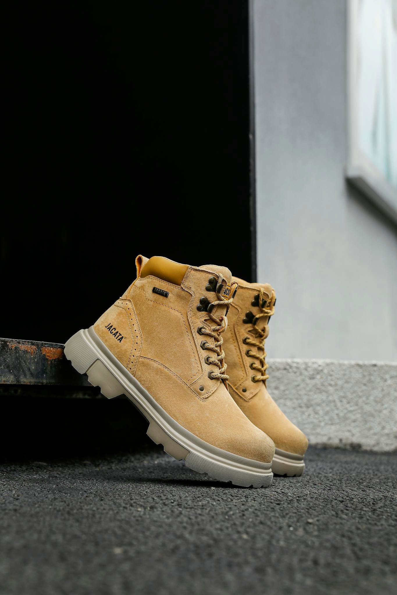 High-quality brown leather boots pictured outdoors on a textured surface. Ideal for fashion and lifestyle themes.